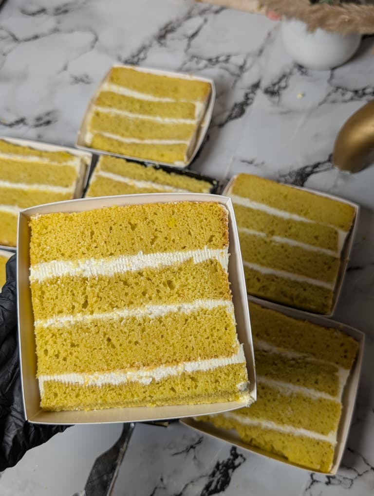 Lemon cake slice with cream layers in a white box