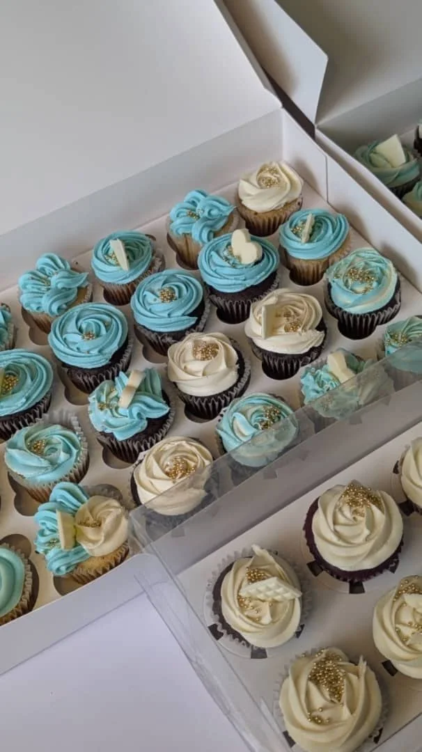 Boxes of blue and cream cupcakes prepared for a customer order